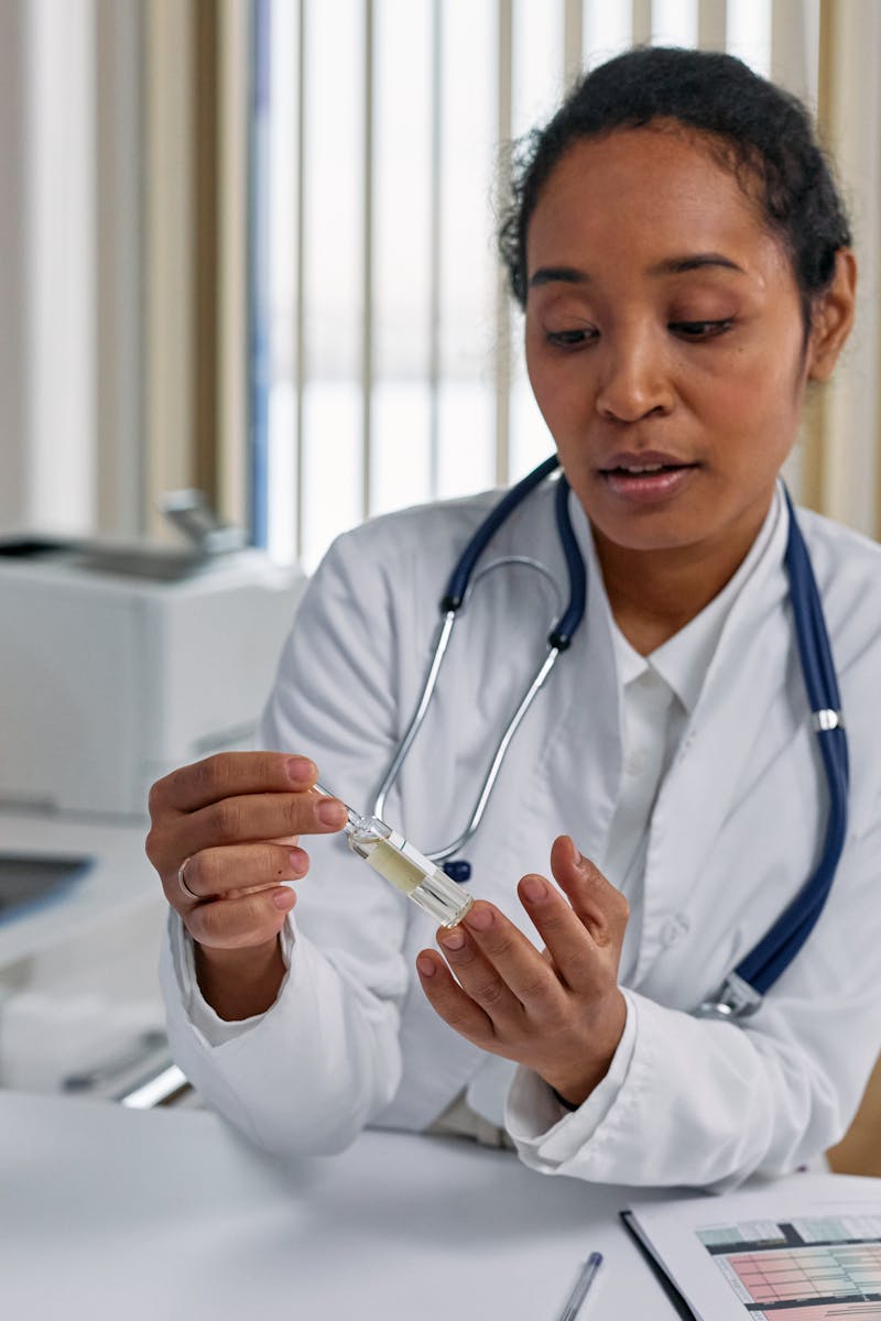 Woman doctor analyzing ampoule in a clinical setting with focused attention.