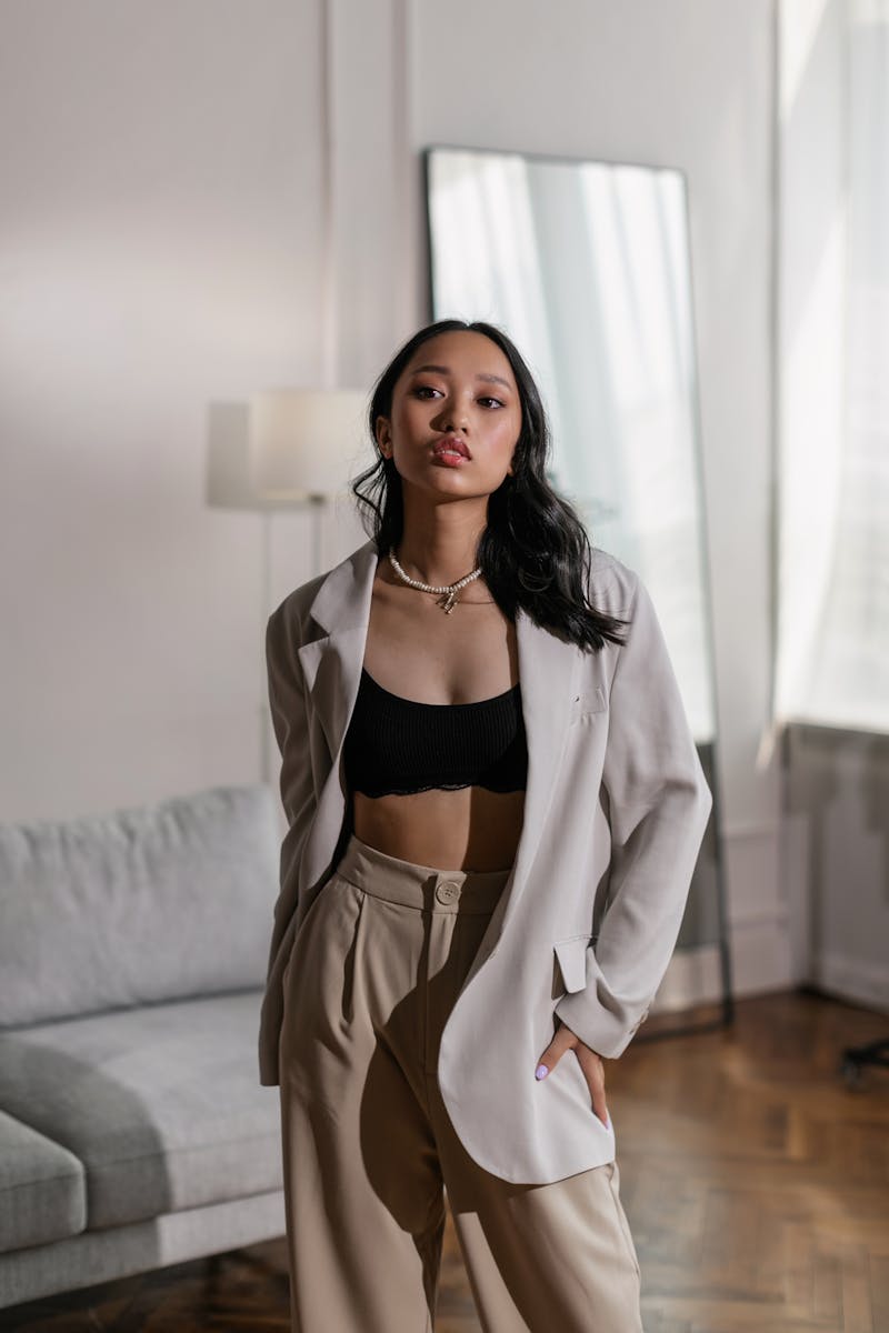 Elegant Asian woman poses in a chic outfit at a modern indoor setting. Perfect for fashion photography.